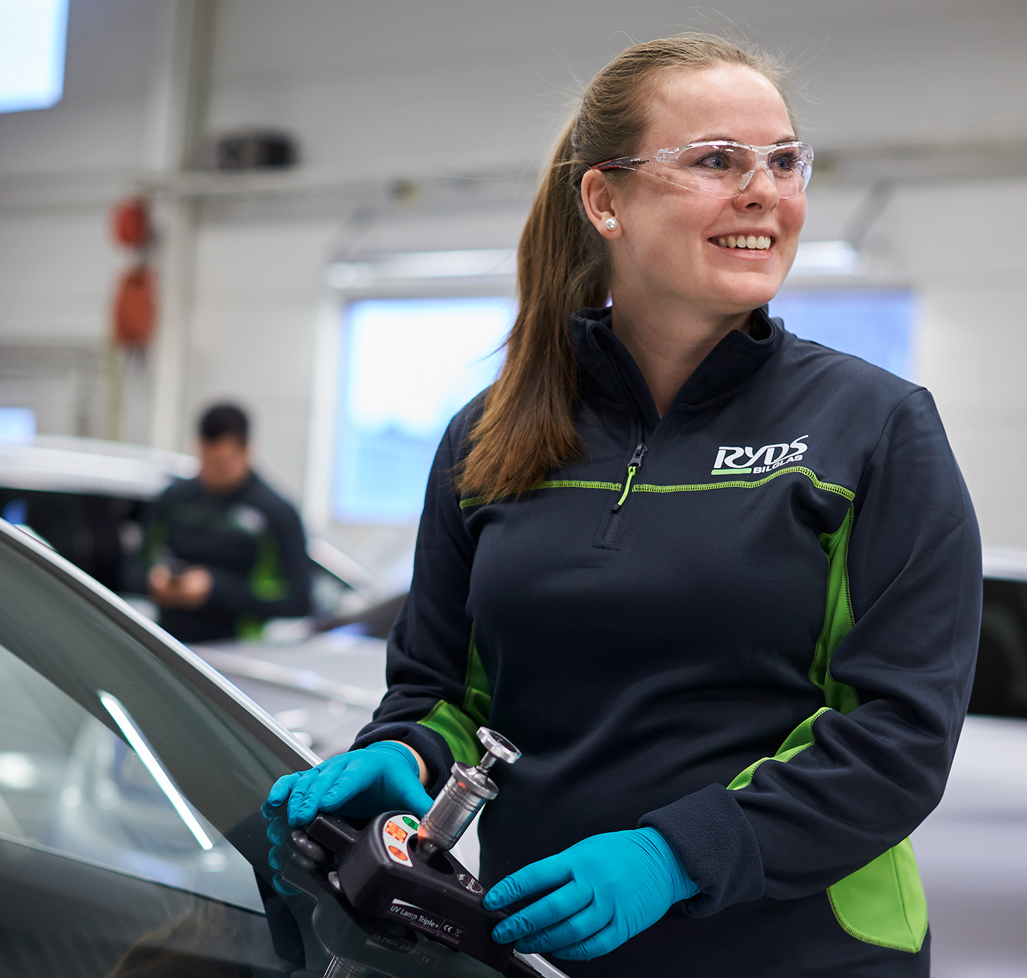 Ryds anställd kvinna använder ett verktyg på en vindruta