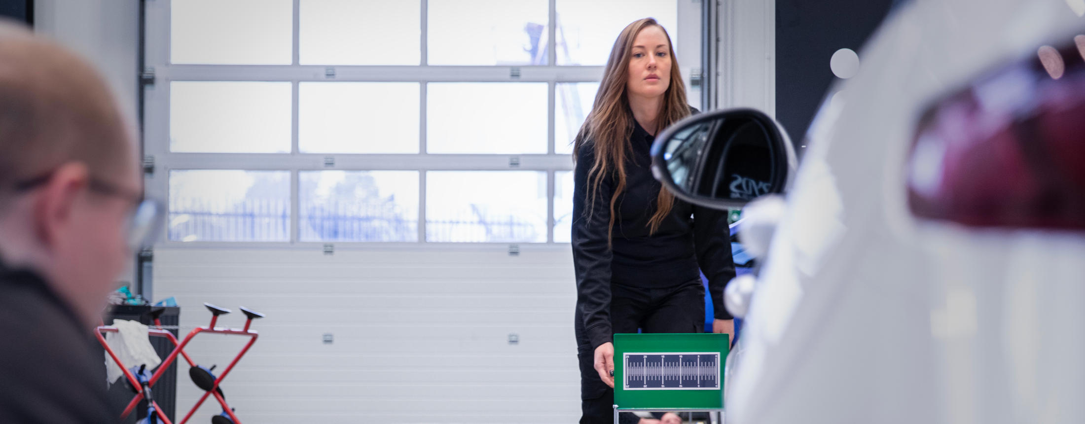 2 Ryds anställda använder instrument för att kalibrera en bil